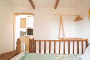 1 dormitorio con cuna de madera y cocina en La Pigoussette en Valensole