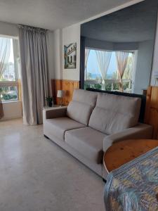 a living room with a couch and a table at Lovely apartment in Torremolinos Views of the sea, pool, terrace, sofa bed and fully equipped kitchen in Torremolinos