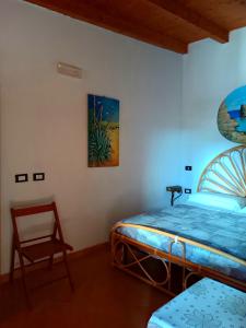 a bedroom with a bed and a chair in a room at A due passi da Cala Pisana in Lampedusa