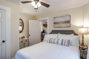 1 dormitorio con cama blanca y ventilador de techo en The Flats on Florida St - Super Comfy 2-Bedroom Apartments, en Mobile