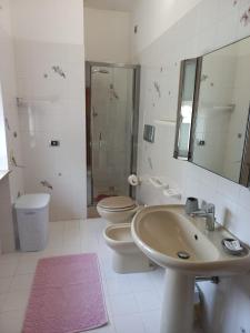 y baño con lavabo, aseo y espejo. en Casa Stefy Gubbio Centro, en Gubbio