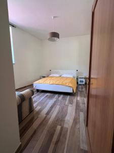 Schlafzimmer mit einem Bett und Holzboden in der Unterkunft Tenuta Lucio in Vietri
