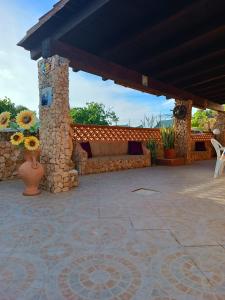 eine Terrasse mit einer Bank und einer Steinmauer in der Unterkunft A due passi da Cala Pisana in Lampedusa