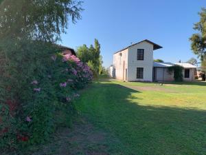 圣胡安Gran Pocito Chalet的一座带房子的院子和一座花丛