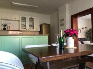 a kitchen with a table with a bottle of wine and flowers at ADELLE cottage in KRKONOŠE national park in Rudník +47 photos