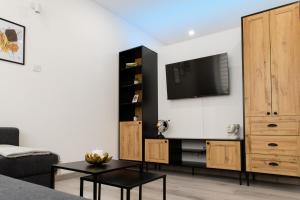 a living room with a flat screen tv on a wall at The Central Border Premium Apartment in Štúrovo