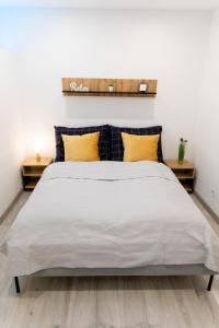 a bedroom with a large white bed with yellow pillows at The Central Border Premium Apartment in Štúrovo