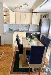 a kitchen with a wooden table and blue chairs at Rooftop terrace appartment in Skopje