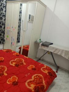 Habitación con cama roja y espejo. en Private room for upto 4 peope, en Sharjah