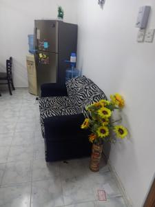 una sala de estar con sofá y un jarrón de flores en Private room for upto 4 peope, en Sharjah
