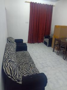 a living room with a zebra couch and a table at Private room for upto 4 peope in Sharjah