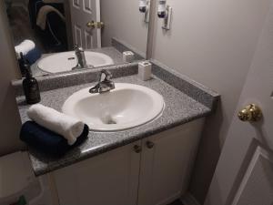 a bathroom with a white sink and a mirror at Lovely and calm townhouse with free parking in London