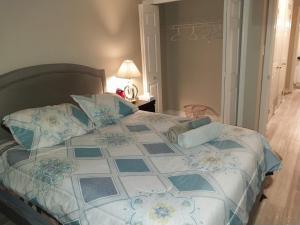 a bed with a blue and white comforter and pillows at Lovely and calm townhouse with free parking in London
