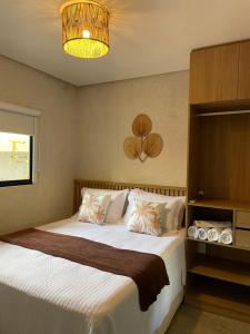 a bedroom with a bed and a chandelier at MAKAI Milagres in São Miguel dos Milagres