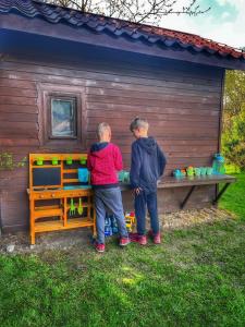 dos jóvenes parados frente a una casa de juegos en Przy Stoku i Potoku, en Wisła