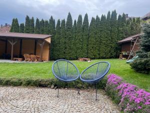 a couple of blue chairs sitting in a yard at Przy Stoku i Potoku in Wisła