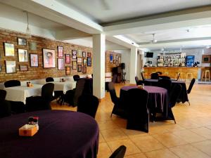 a restaurant with tables and chairs with purple table cloth at Altamont West Hotel in Montego Bay