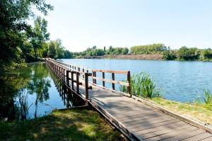 eine Holzbrücke über einen Wasserkörper in der Unterkunft Cosy maison in Oupeye