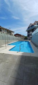 a large blue swimming pool next to a building at La Escollera Noja in Noja