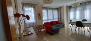 a living room with a couch and a table with red pillows at La Escollera Noja in Noja
