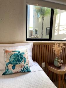 a bedroom with a bed with a turtle pillow on it at MAKAI Milagres in São Miguel dos Milagres