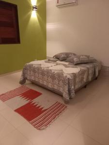 um quarto com uma cama com um tapete no chão em pousada Cantinho da mata em Paraty