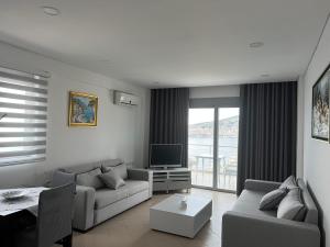 a living room with a couch and a tv at Lorenso Guest House in Sarandë