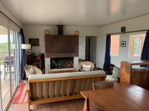 a living room with a fireplace and a table at Villa Blanca in Villa Serrana