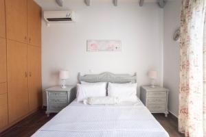 a bedroom with a white bed with two night stands at Green Garden Private Villa in Porto Heli +40 photos