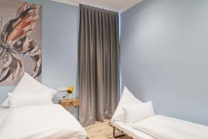 a bedroom with two beds and a painting on the wall at Design Studio I 3 Personen I Innenstadt I Küche I WIFI in Bingen am Rhein