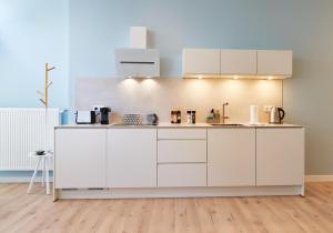 a kitchen with white cabinets in a room at Design Studio I 3 Personen I Innenstadt I Küche I WIFI in Bingen am Rhein +10 photos