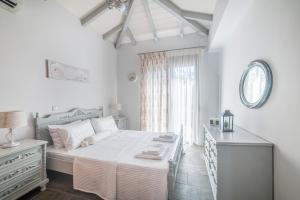 a bedroom with a bed and a dresser and a window at Green Garden Private Villa in Porto Heli