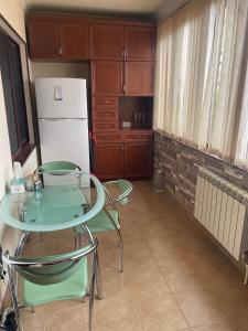 a kitchen with a table and two chairs and a refrigerator at Apartment to rent in Yerevan in Yerevan