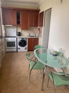 a kitchen with a glass table and green chairs at Apartment to rent in Yerevan in Yerevan