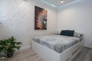 ein Schlafzimmer mit einem Bett und einem Gemälde an der Wand in der Unterkunft Apartment Viktorija in Dubrovnik
