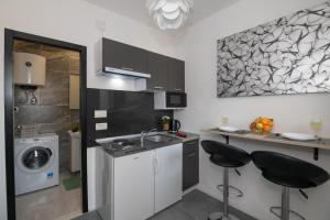 eine Küche mit einem Waschbecken und 2 Barhockern in der Unterkunft Apartment Viktorija in Dubrovnik
