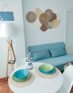 een witte tafel met borden en een blauwe bank bij El Mirador de Torremari - Nudista - Vera playa in Vera