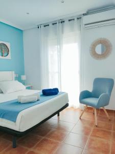 a bedroom with a bed and a chair at El Mirador de Torremari - Nudista - Vera playa in Vera