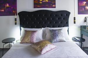 a bed with a black headboard and two pillows at Boutique Hotel Ferrara in Ferrara