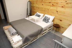a bedroom with a bed and a wooden wall at LAKE HOUSE 'VILIN KONAK' in Nikšić
