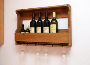 a wooden shelf with wine bottles and wine glasses at LAKE HOUSE 'VILIN KONAK' in Nikšić