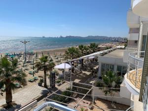 a view of a beach with chairs and umbrellas at Wave Beachfront Apartments in Durrës