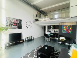 a living room with a couch and a tv and a table at Loft Confort in Alcalá de Henares