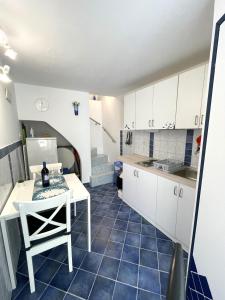 a kitchen with white cabinets and a blue tile floor at APARTMENT NUNA in Baška