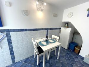 a kitchen with a table and chairs and a small refrigerator at APARTMENT NUNA in Baška