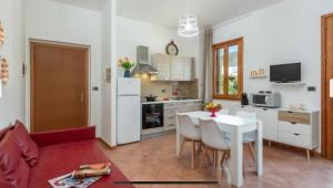a kitchen and living room with a white table and chairs at Blue Coral in San Vito lo Capo +5 photos