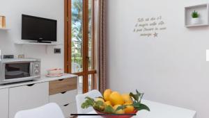a kitchen with a table with a bowl of fruit at Blue Coral in San Vito lo Capo