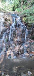 a waterfall on the side of a rocky hill at Casa do Monte in Castro Daire