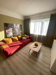 a living room with a red couch and a table at Quiet and peaceful apartment close to the city center in Rīga