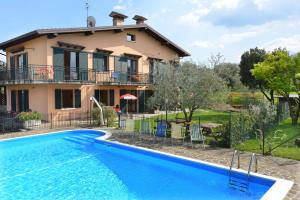 a villa with a swimming pool in front of a house at La Grolla Apartments in Manerba del Garda